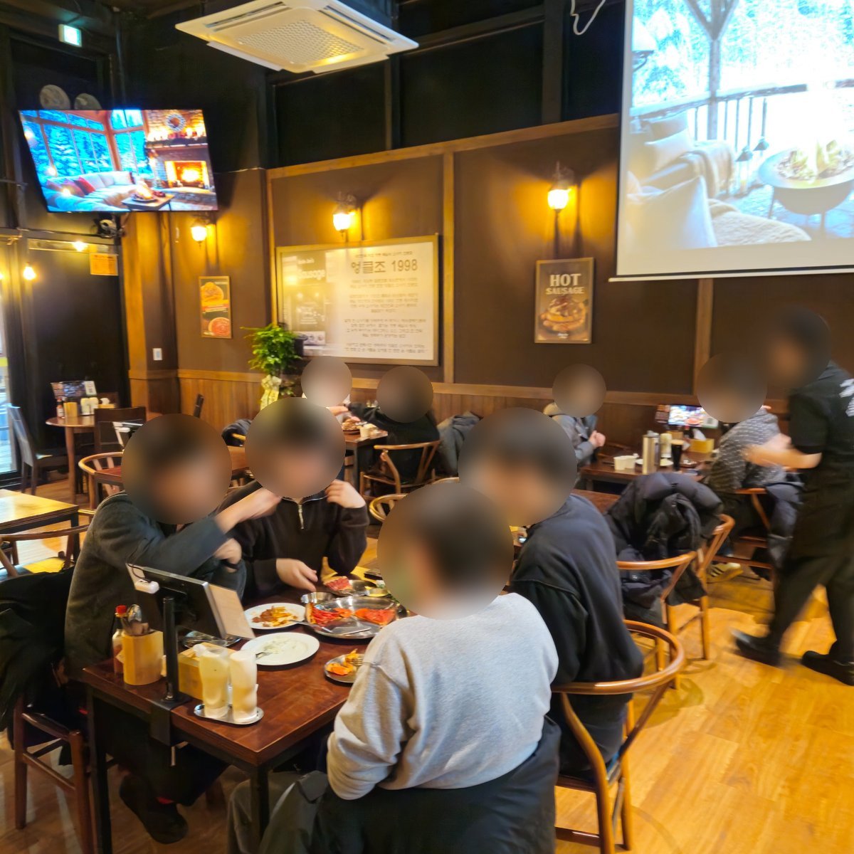 김포구래점 내부 - 고객들이 소시지와 맥주를 즐기는 활기찬 분위기